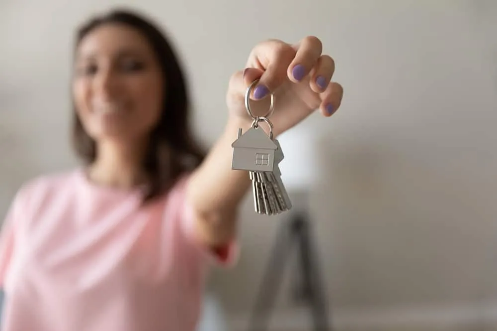 Close,Up,Of,Happy,Female,Renter,Tenant,Show,Keys,Buy